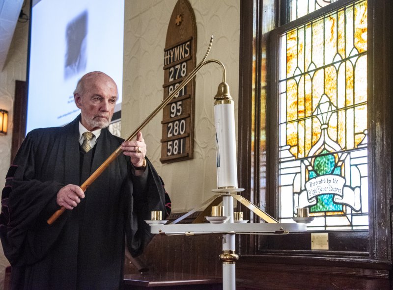 The Rev. Dr. S. Willard Crossan III, Groome Church pastor, snuffs out the last candle while the Shrewsbury String Quartet plays the final sonata.